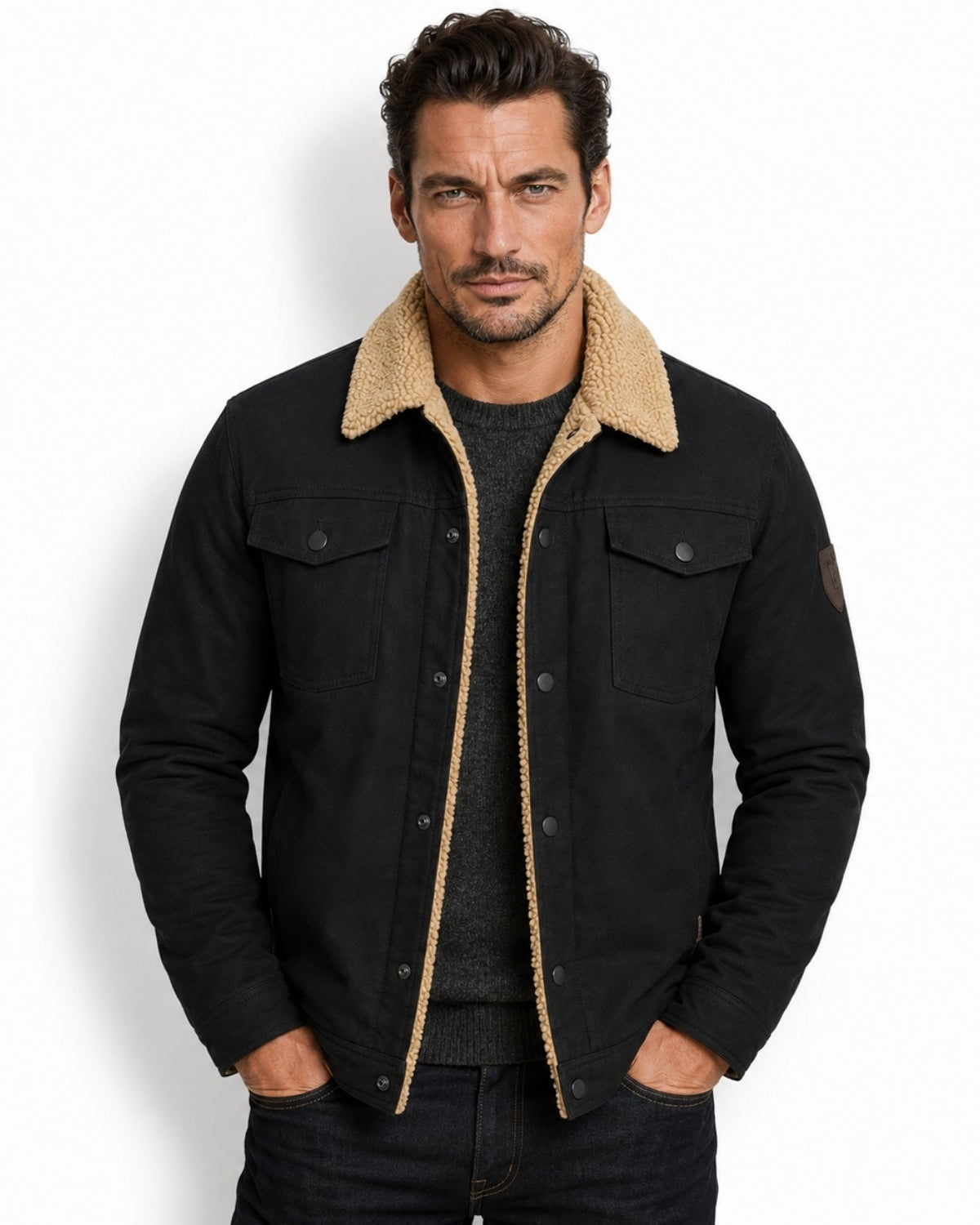 Model wearing men's black sherpa lined trucker jacket over a charcoal sweater, showcasing the faux shearling collar.
