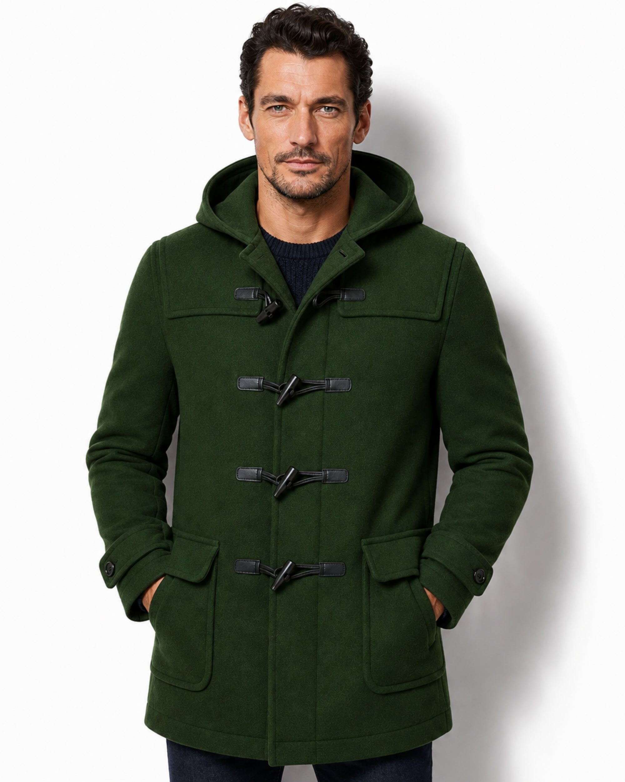 Front view of a man wearing the luxury forest green wool duffle coat with black toggle closures and a structured hood.