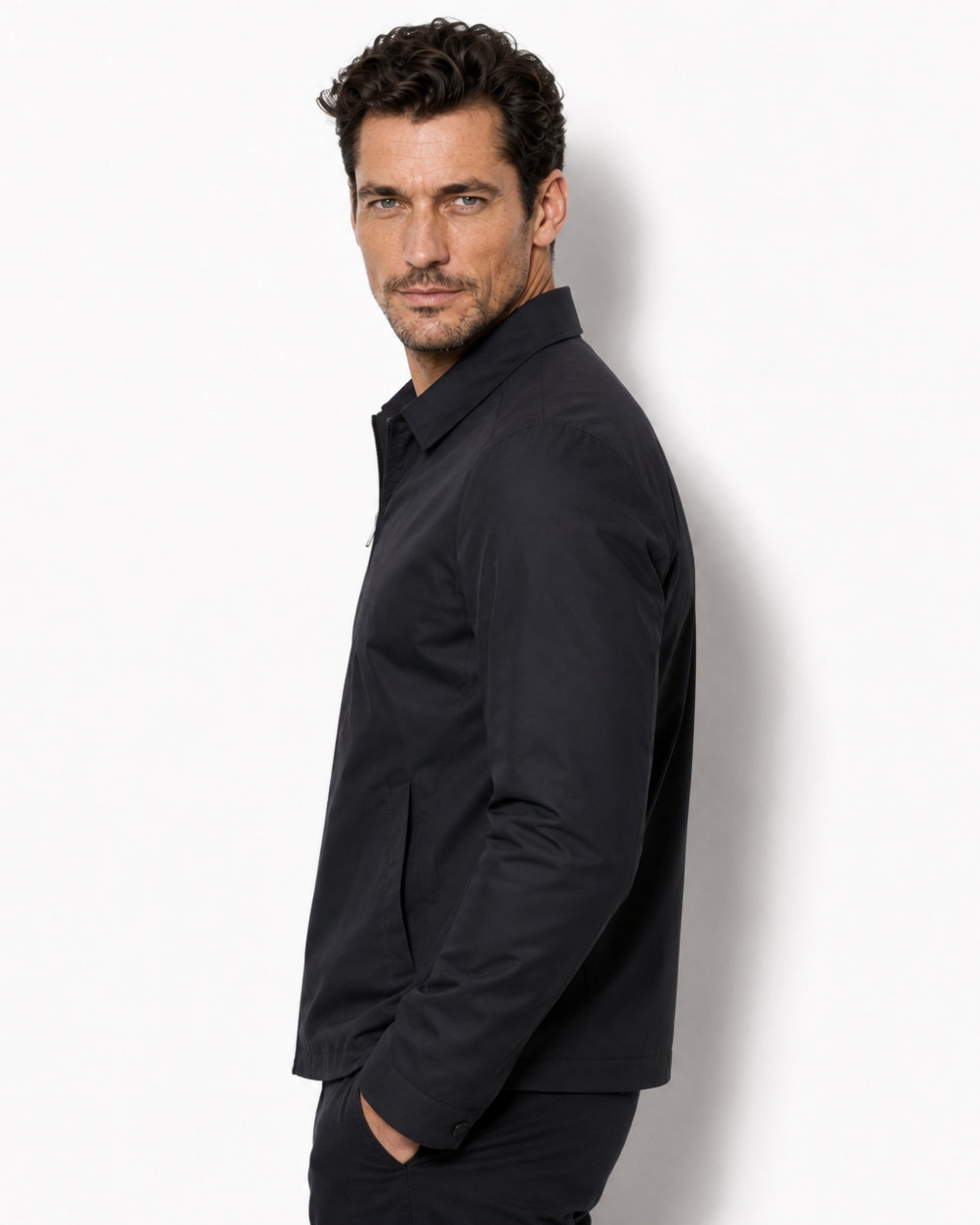 Side profile of a male model showcasing the tailored fit of the premium black zip-up windbreaker jacket.